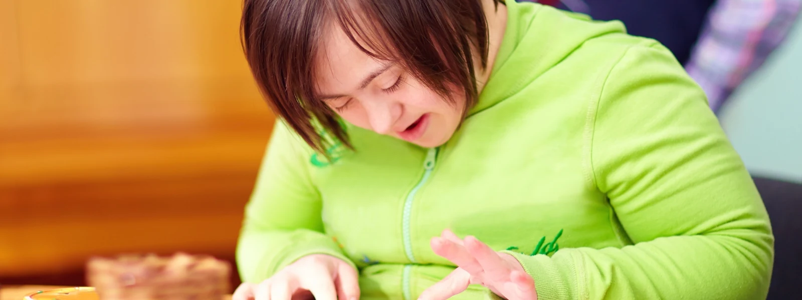 Care workers and residents sharing laughter around a board game in a warm, homely living room